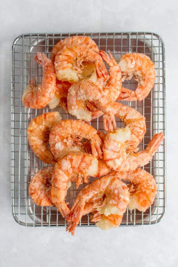 Fried shrimp on a cooling rack.