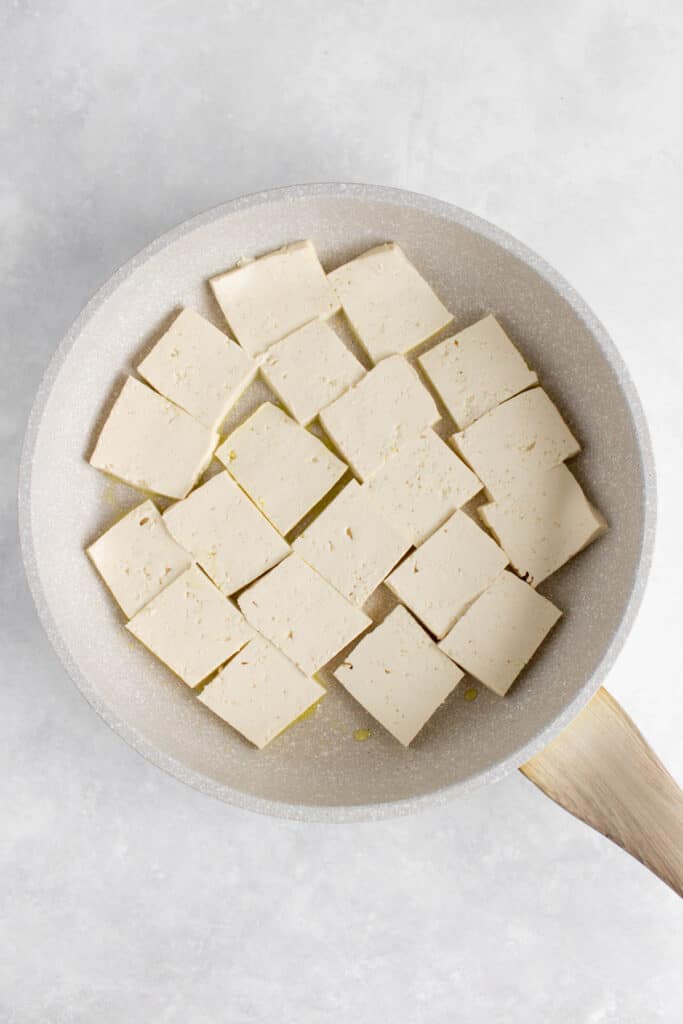 Tofu square slices in a pan.