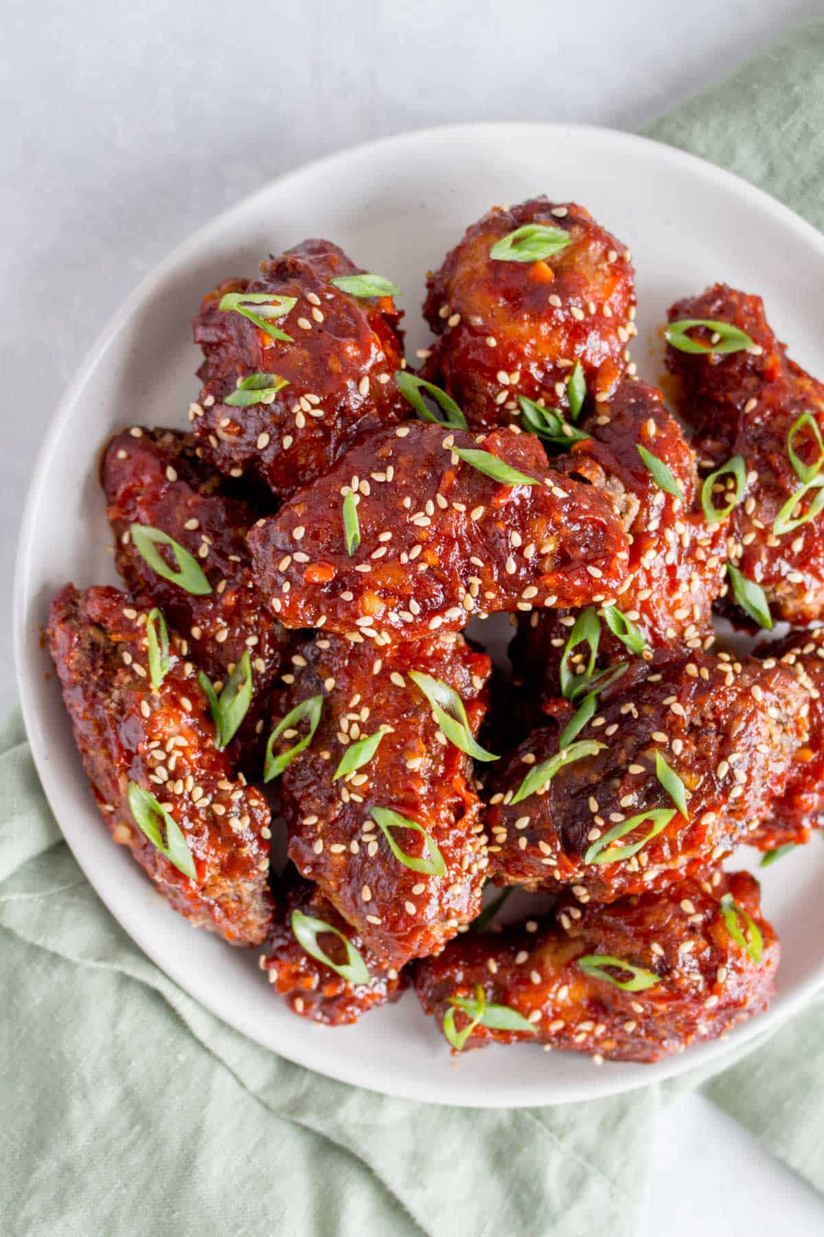 Close up of Korean fried chicken wings on a plate.