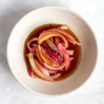 Overhead view of a small bowl with Korean pickled red onions.