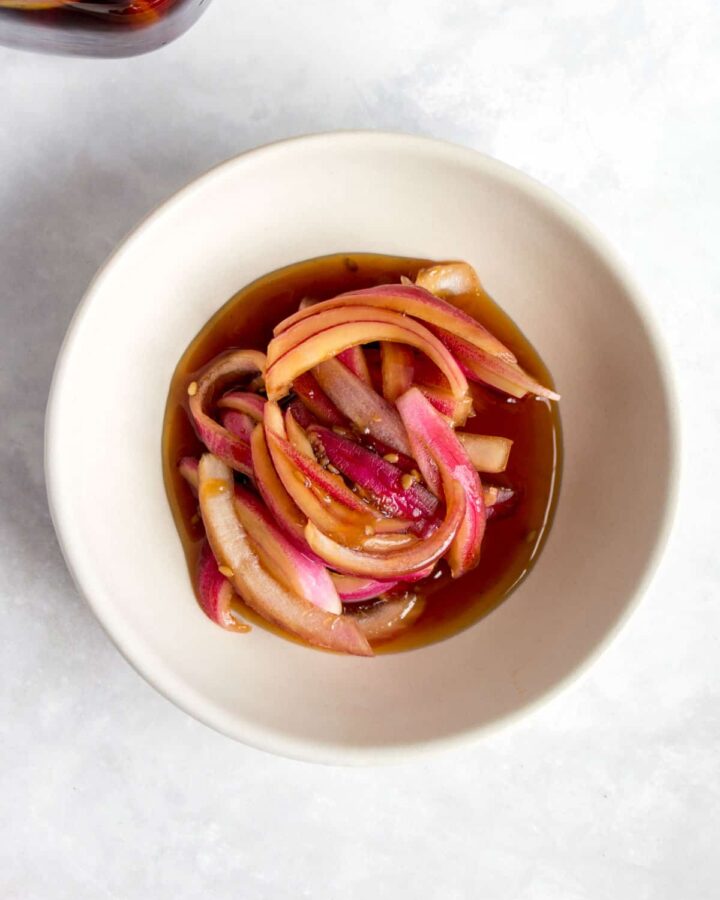 Overhead view of a small bowl with Korean pickled red onions.