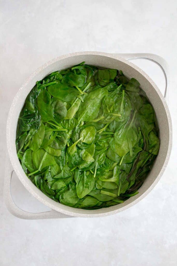 Spinach blanched in a pot of water.