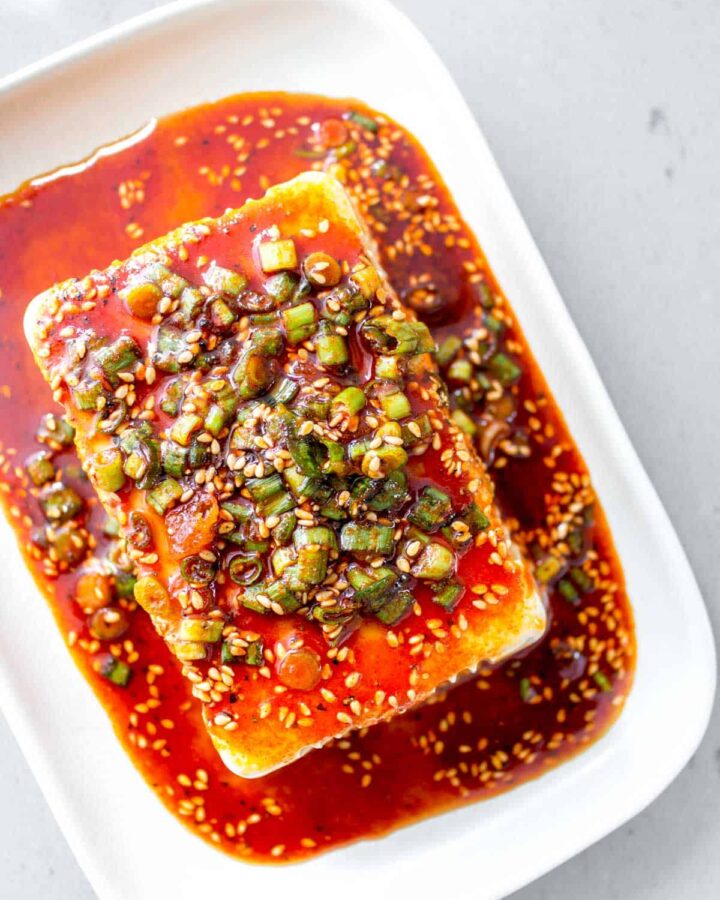Overhead view of silken tofu with soy sesame sauce on top.