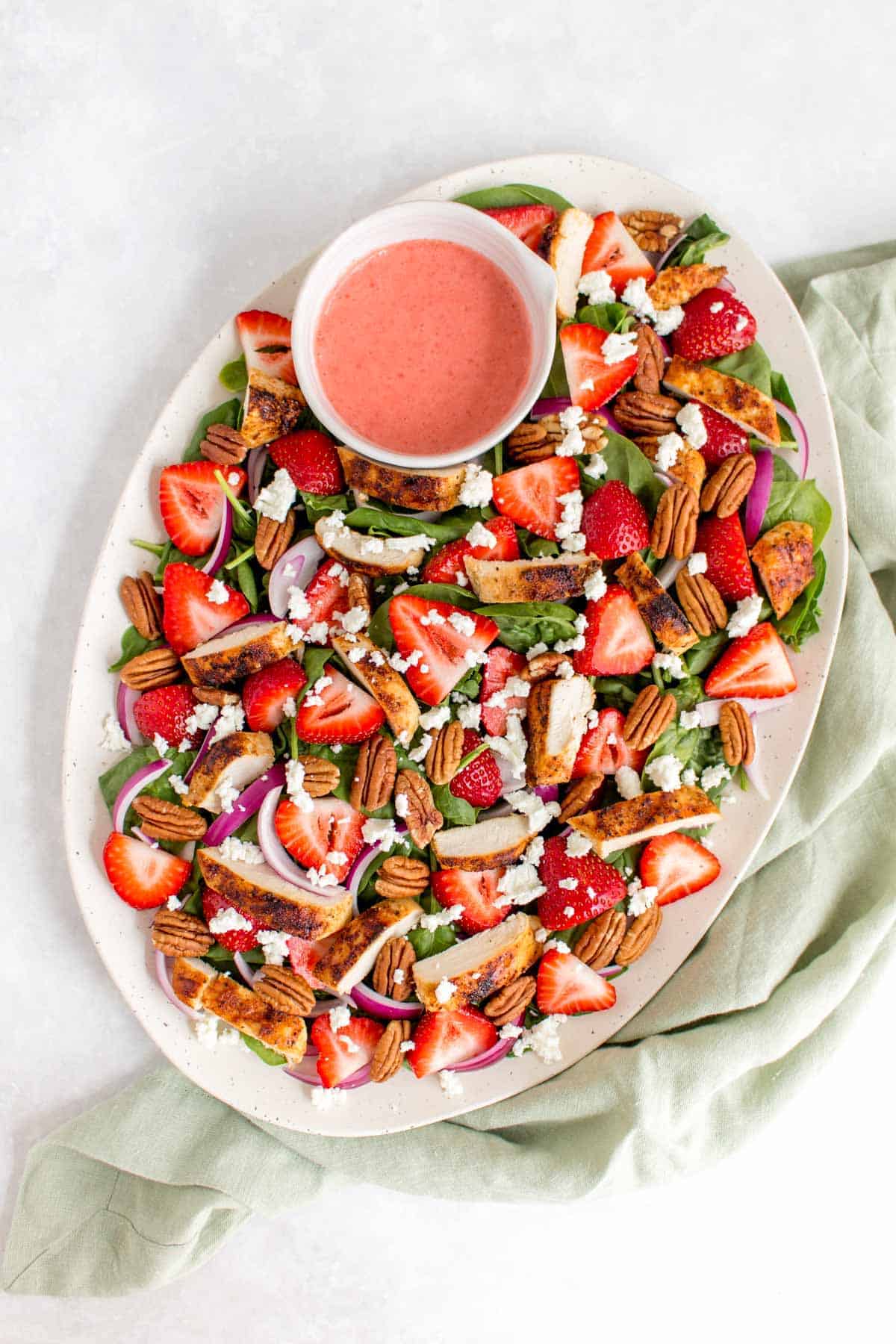 Overhead view of a platter of strawberry spinach salad.