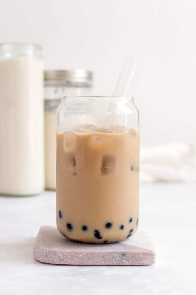 A glass of cold brew milk tea with tapioca and brown sugar.
