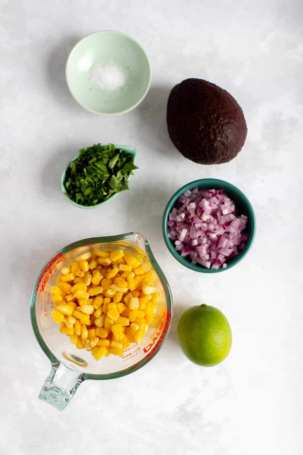 Ingredients needed to make corn avocado salsa.