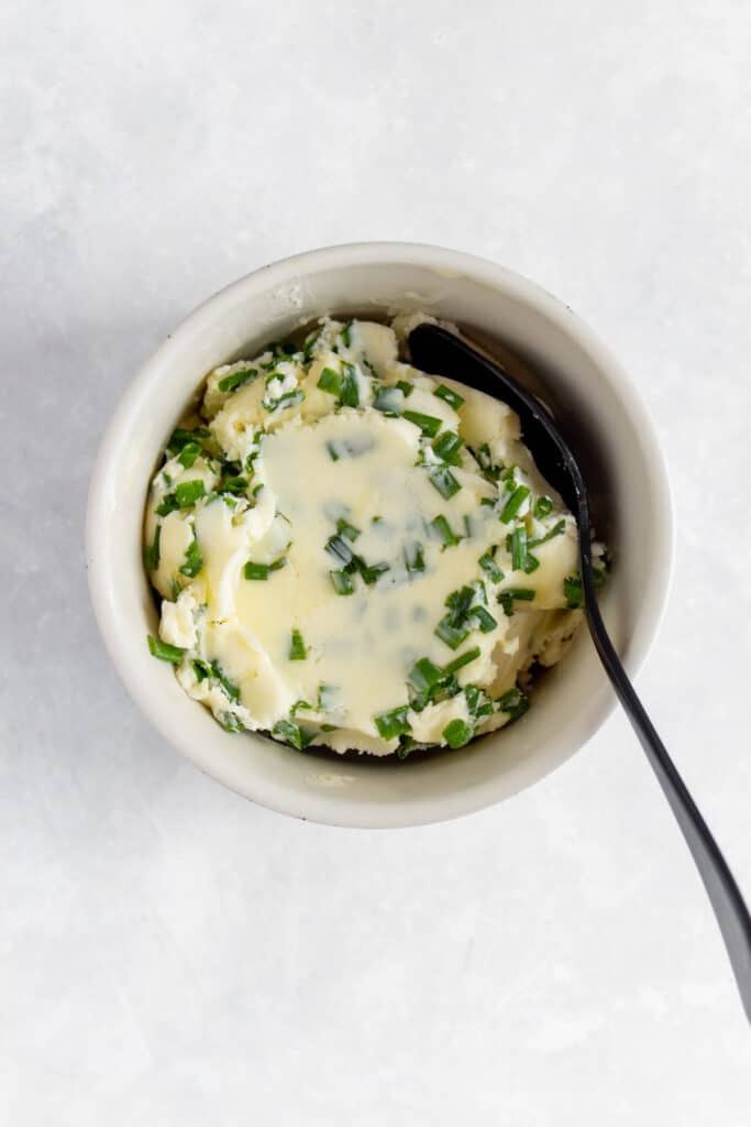 Butter combined with chives in a bowl.