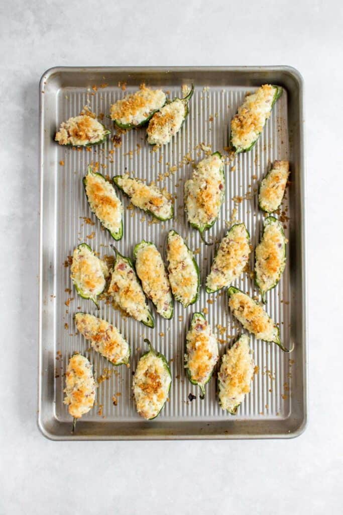 Baked jalapeno poppers on a sheet pan.