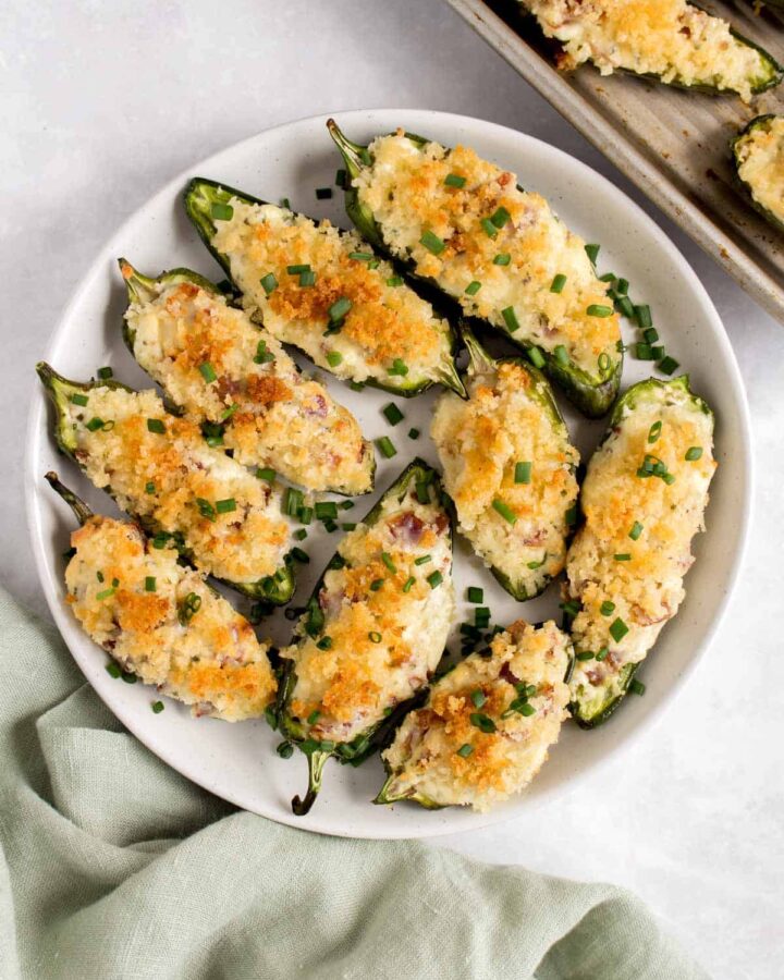A plate of jalapeno poppers topped with chives.