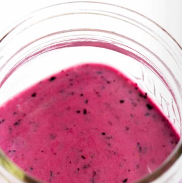 Close up of a jar of blueberry vinaigrette.