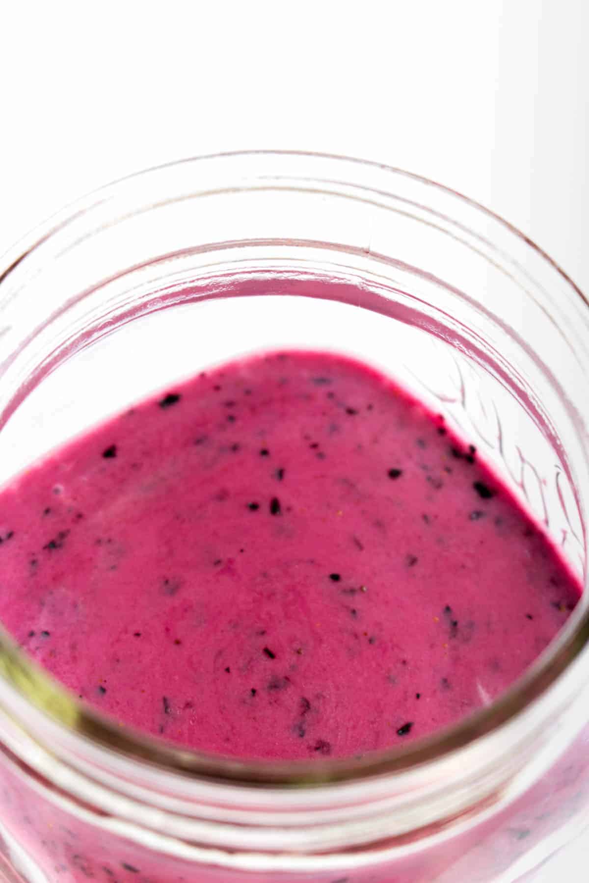 Close up of a jar of blueberry vinaigrette.