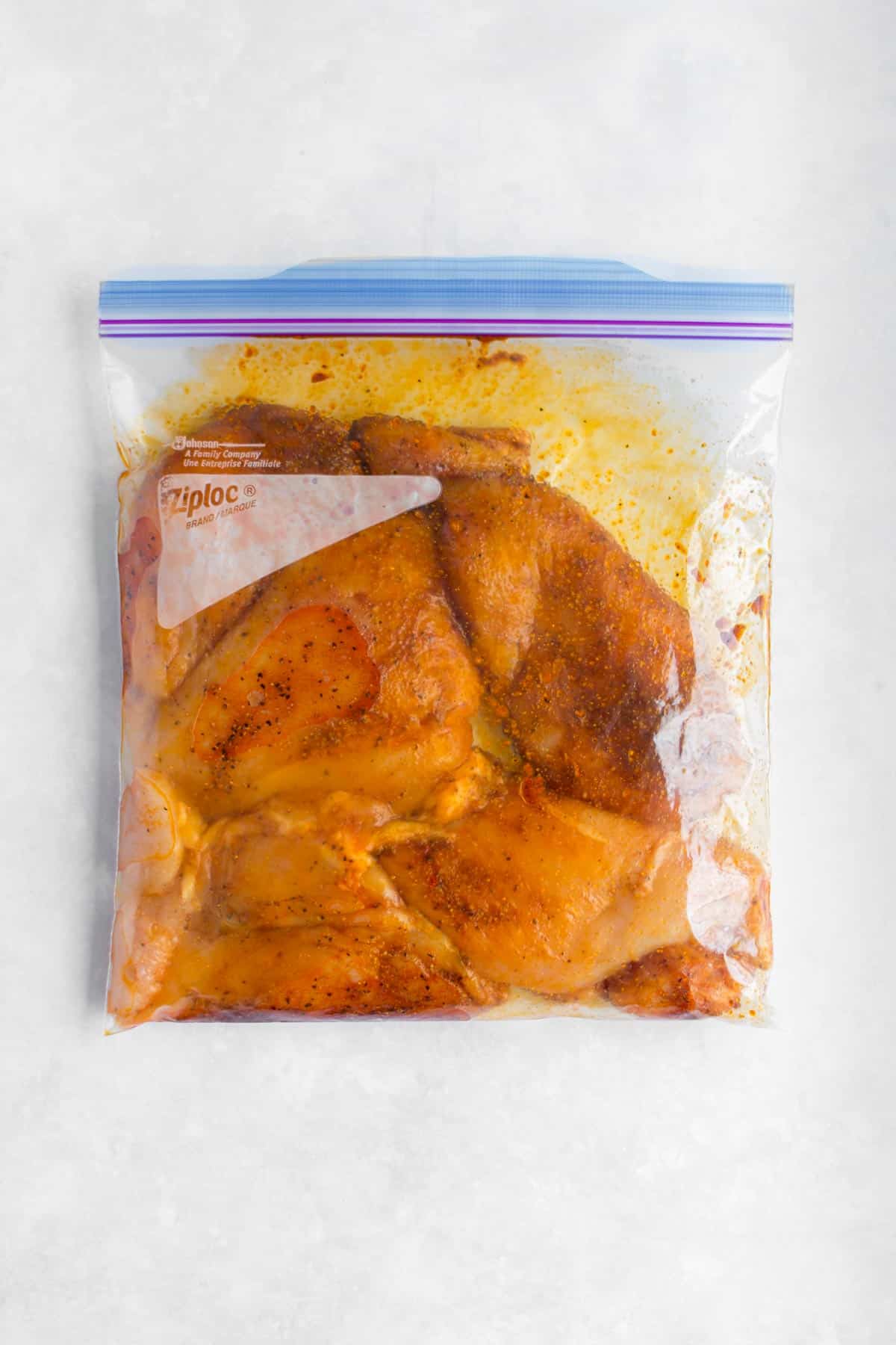 Marinaded chicken breasts in a ziploc bag.