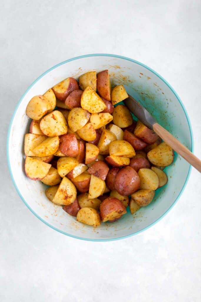 Quartered potatoes coated with oil and seasoning.