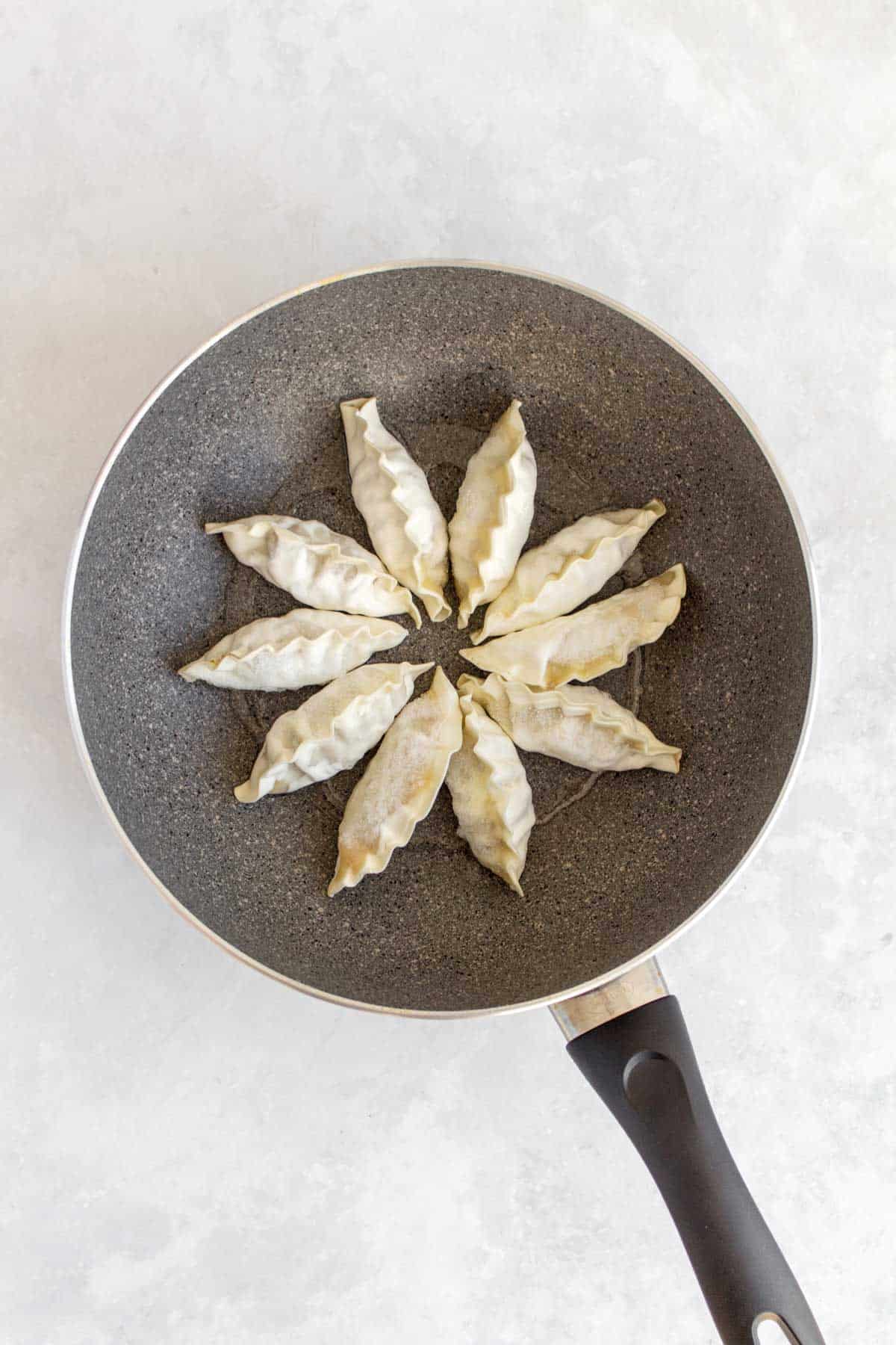 Dumplings in a non-stick pan.