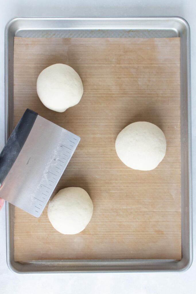 Dough balls on a sheet pan before rising.