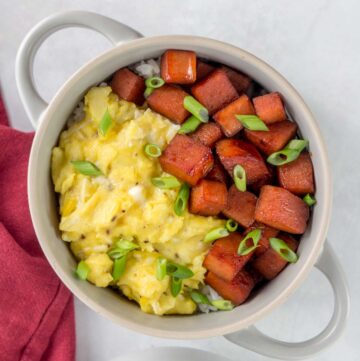 A bowl of spam and eggs over rice.