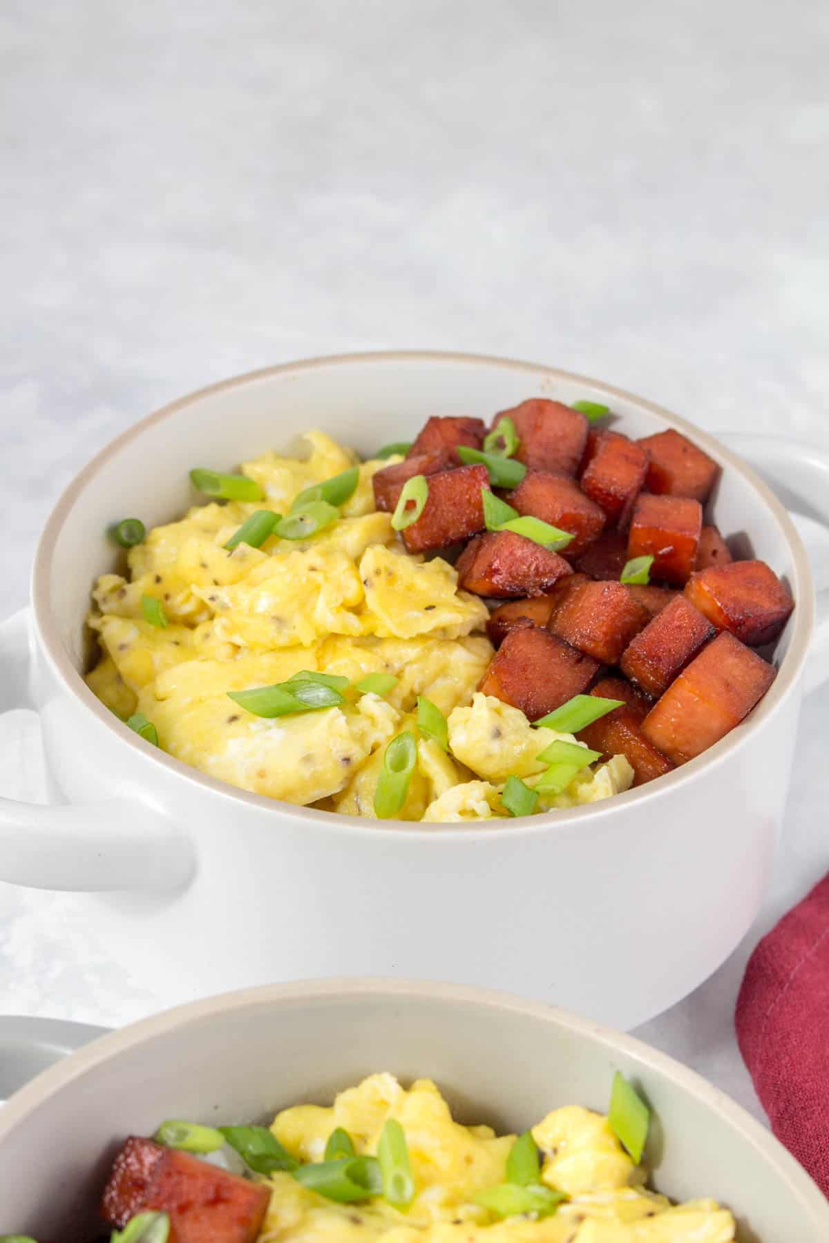A bowl of spam and eggs over rice.