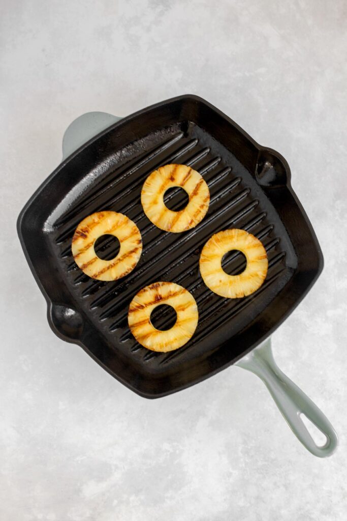 Pineapple rings grilled in a grill pan.