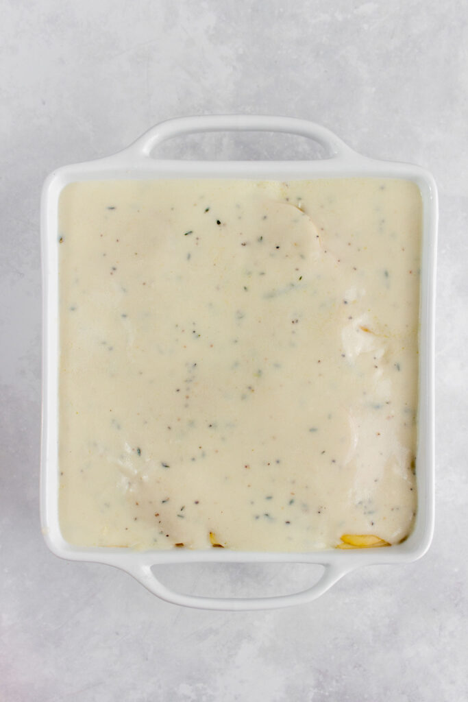 White sauce added to the baking dish.