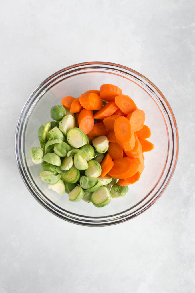 A bowl of brussels sprouts and carrots.