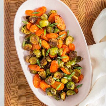 A platter of roasted brussels sprouts and carrots.