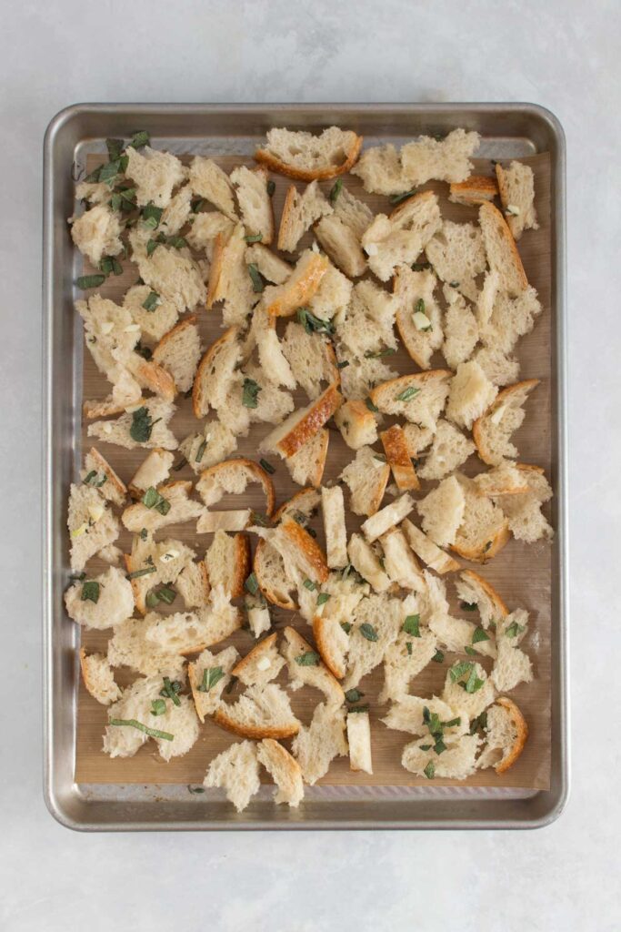 Sheet pan with bread with garlic herb butter.