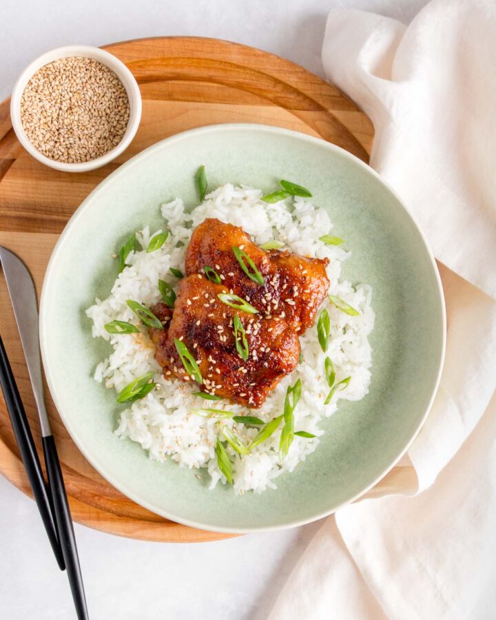 A plate with rice and teriyaki chicken thighs.