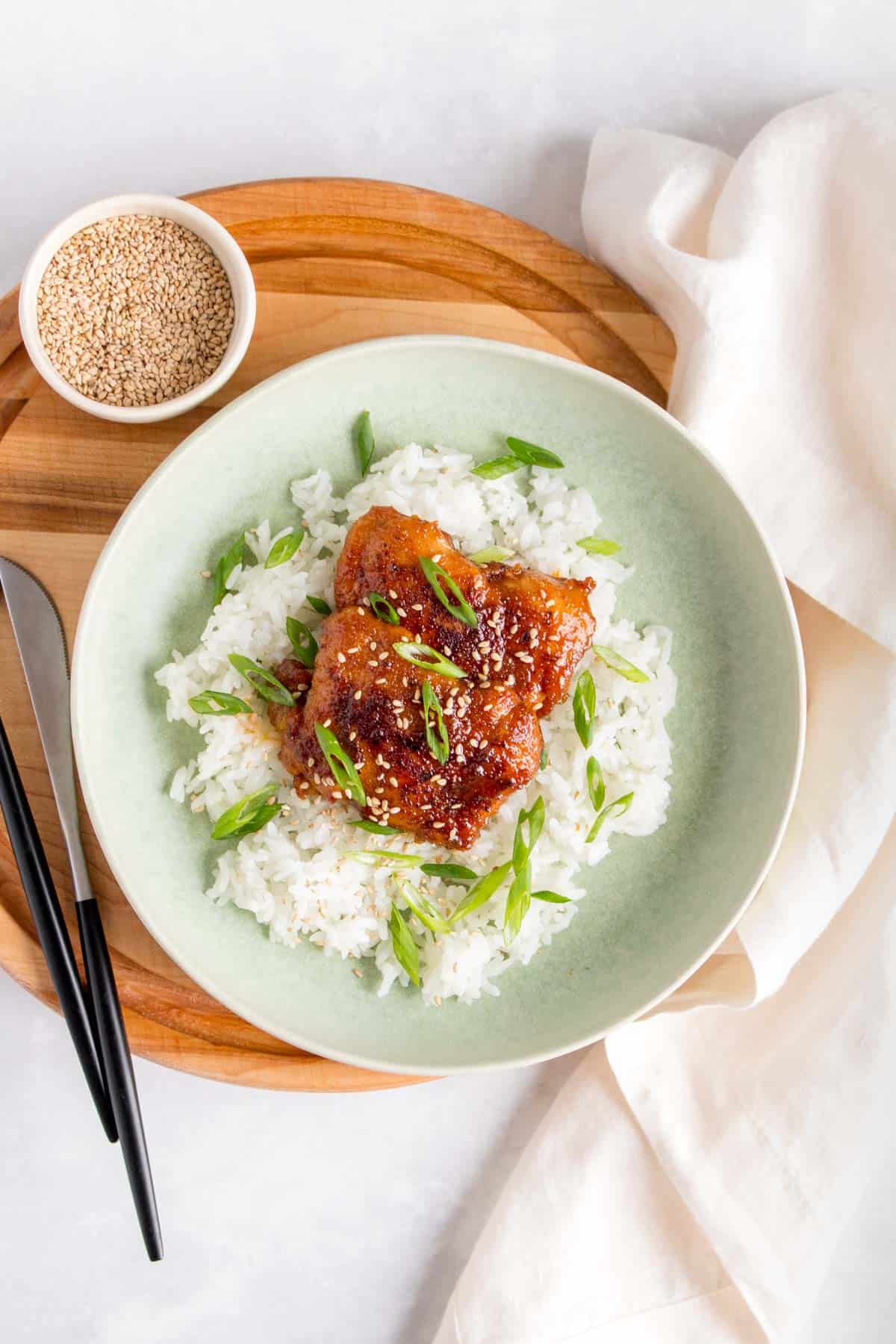 A plate with rice and teriyaki chicken thighs.