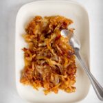 Caramelized onion on a plate with a spoon.