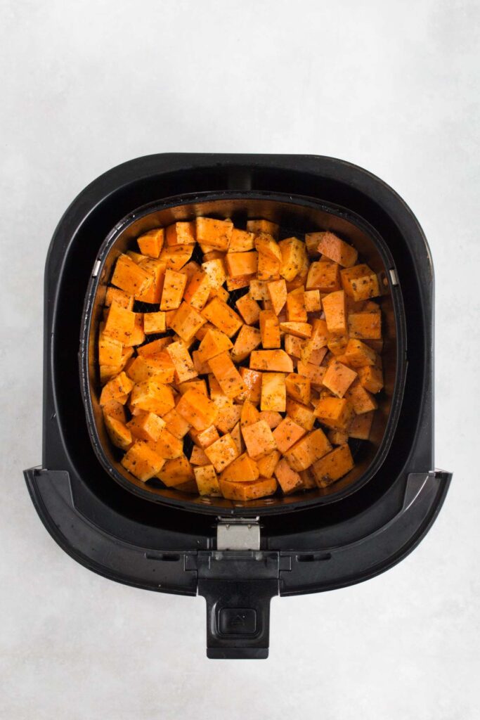 Sweet potato cubes in the air fryer basket.