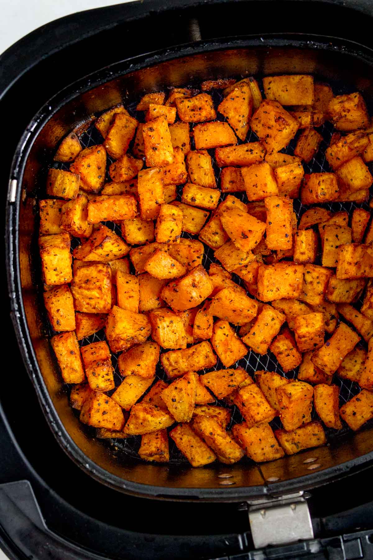 Close up of air fryer sweet potato cubes.