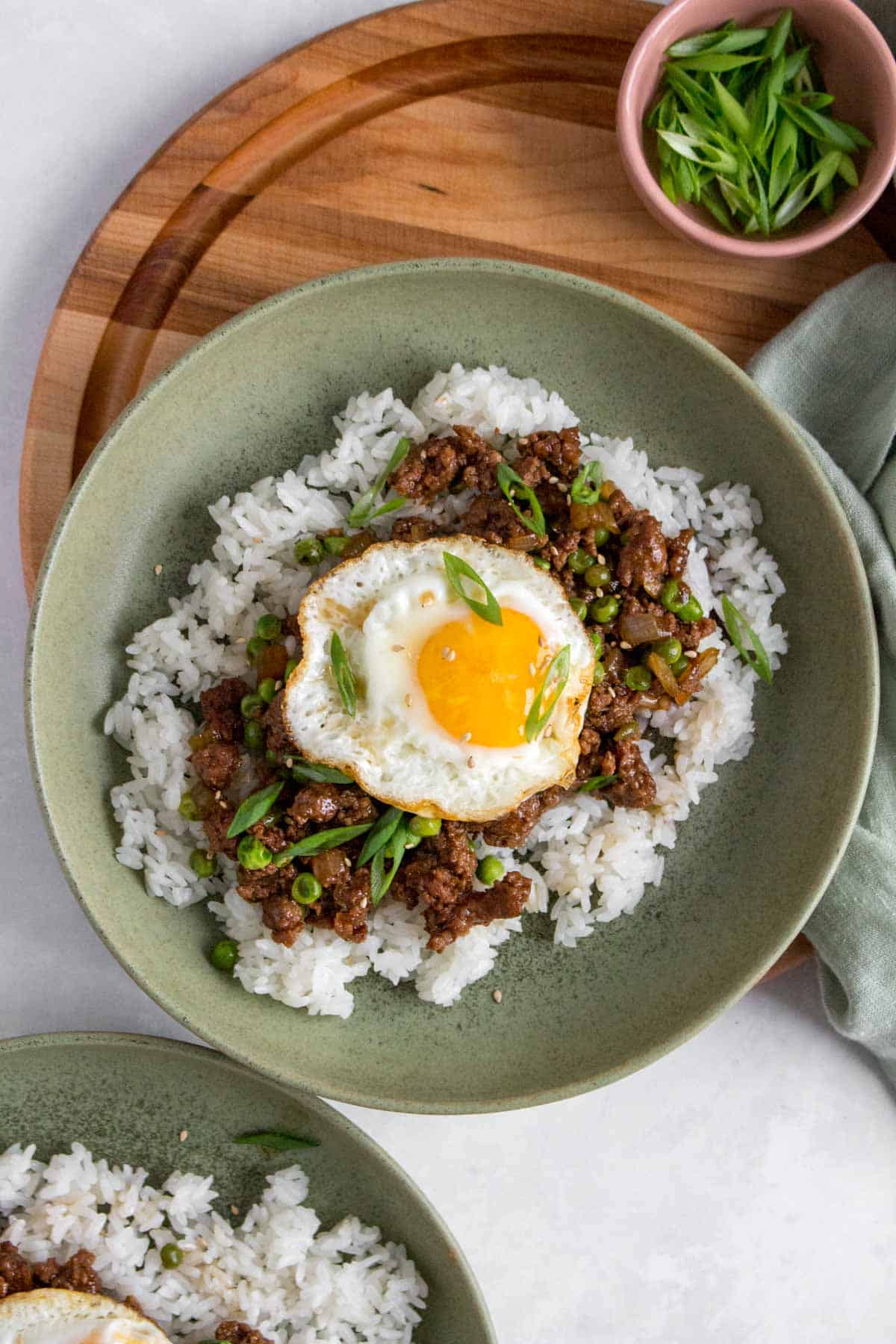 A bowl of rice with ground beef and fried egg on top.