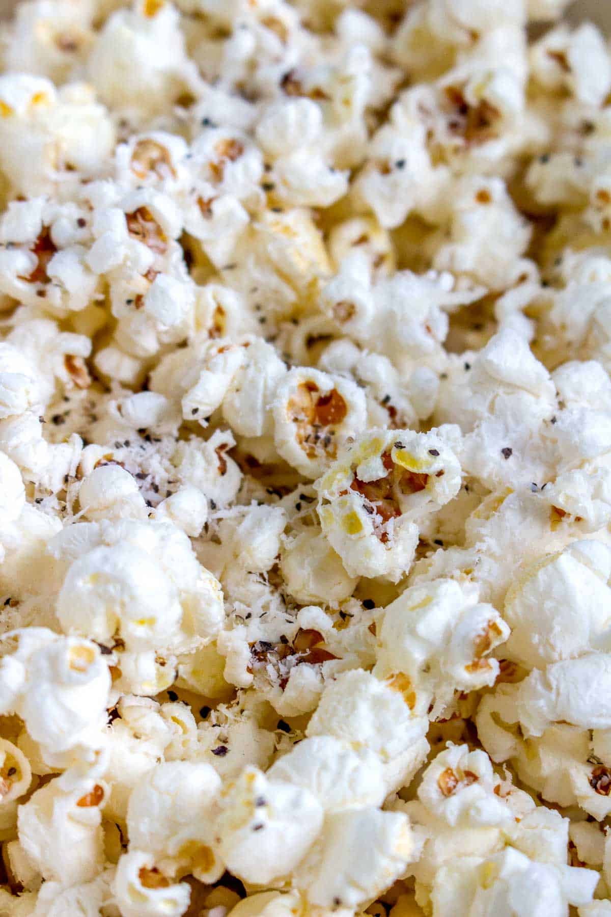 Close up of popcorn with parmesan and black pepper.
