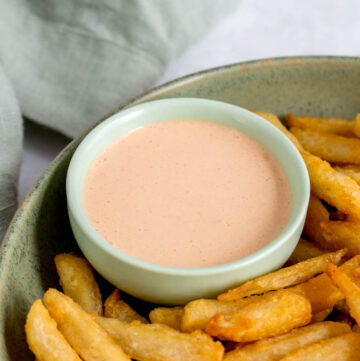 A dipping bowl of chipotle lime crema with fries.