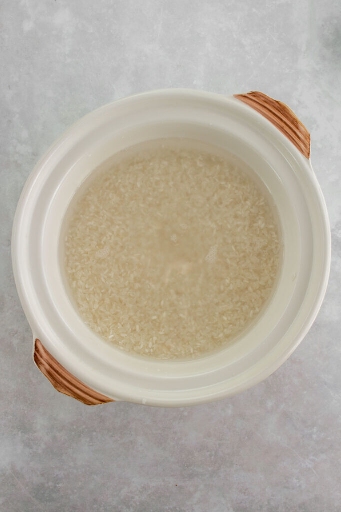 A donabe pot with rinsed rice and water.