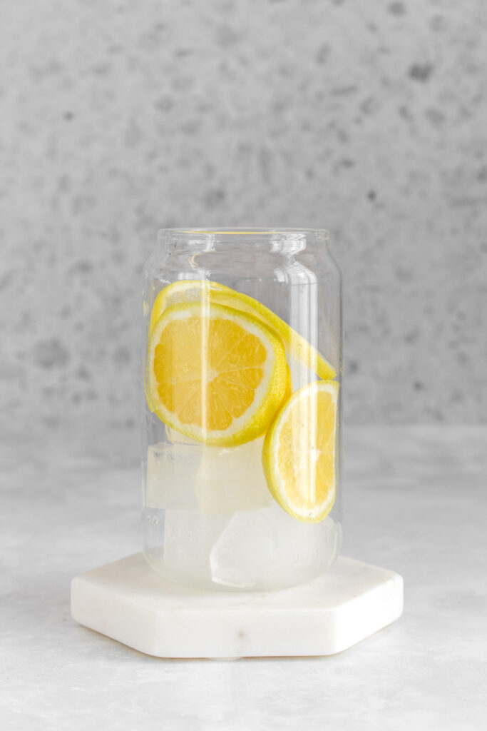 Glass with ice and sliced lemons.