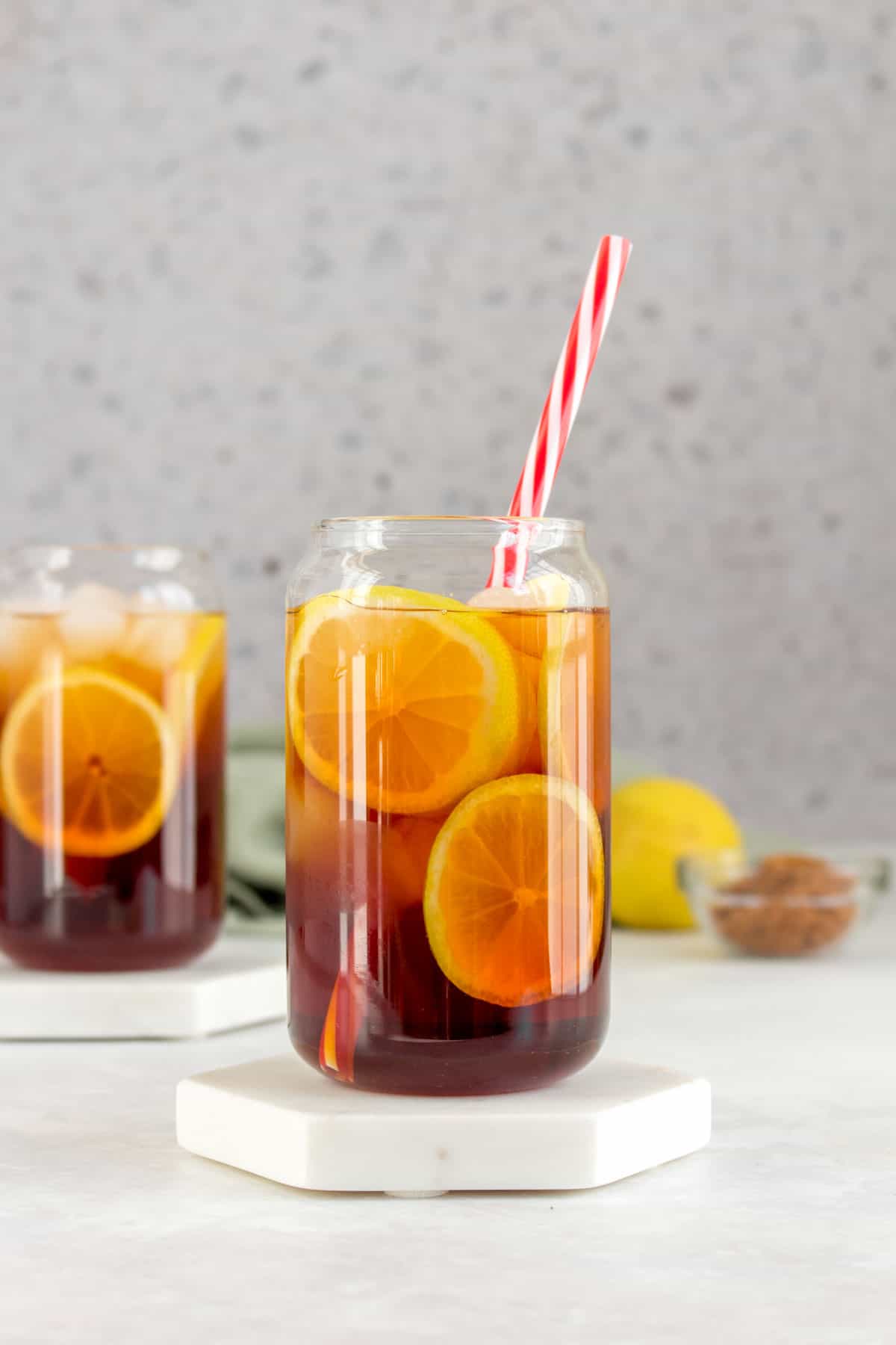 A glass of hong kong lemon tea with a straw.