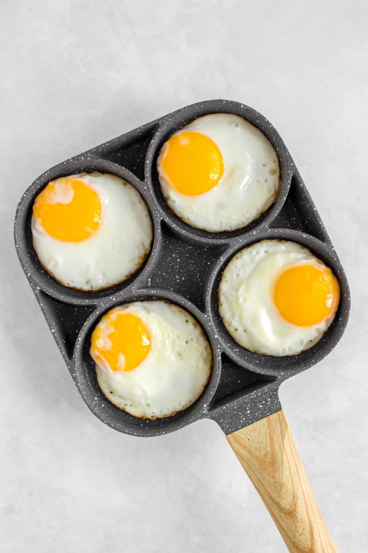 Fried sunny side up eggs in a pan.