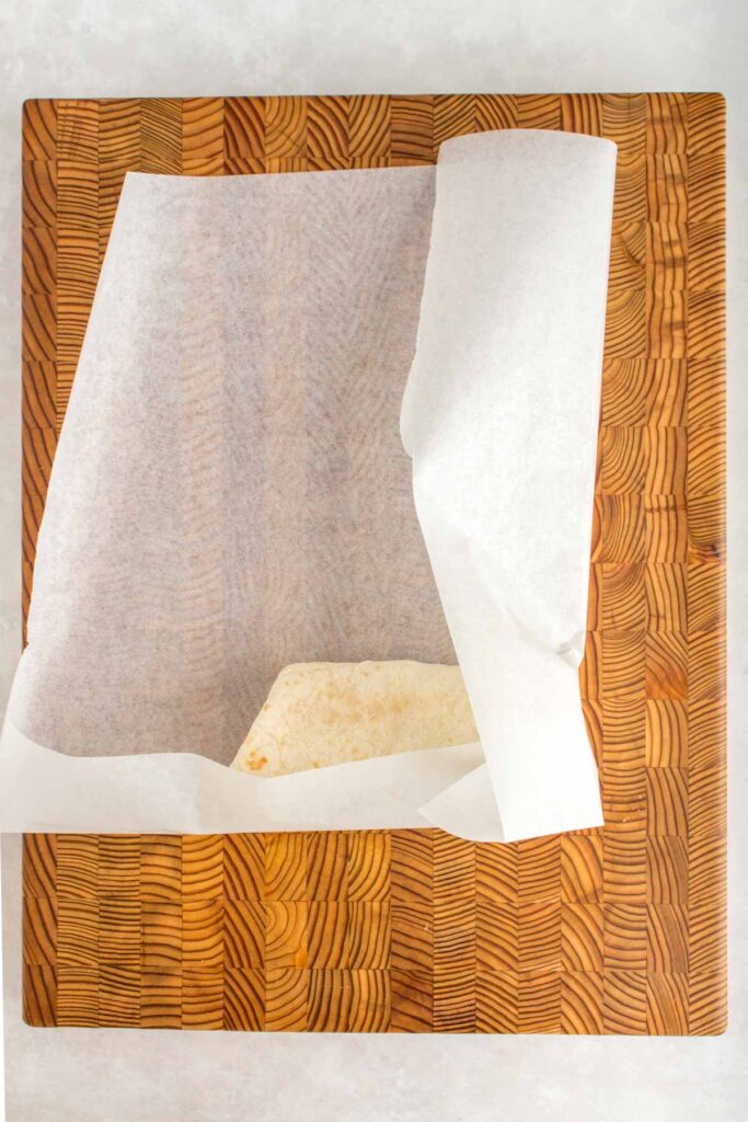 Wrapping a breakfast wrap with parchment.