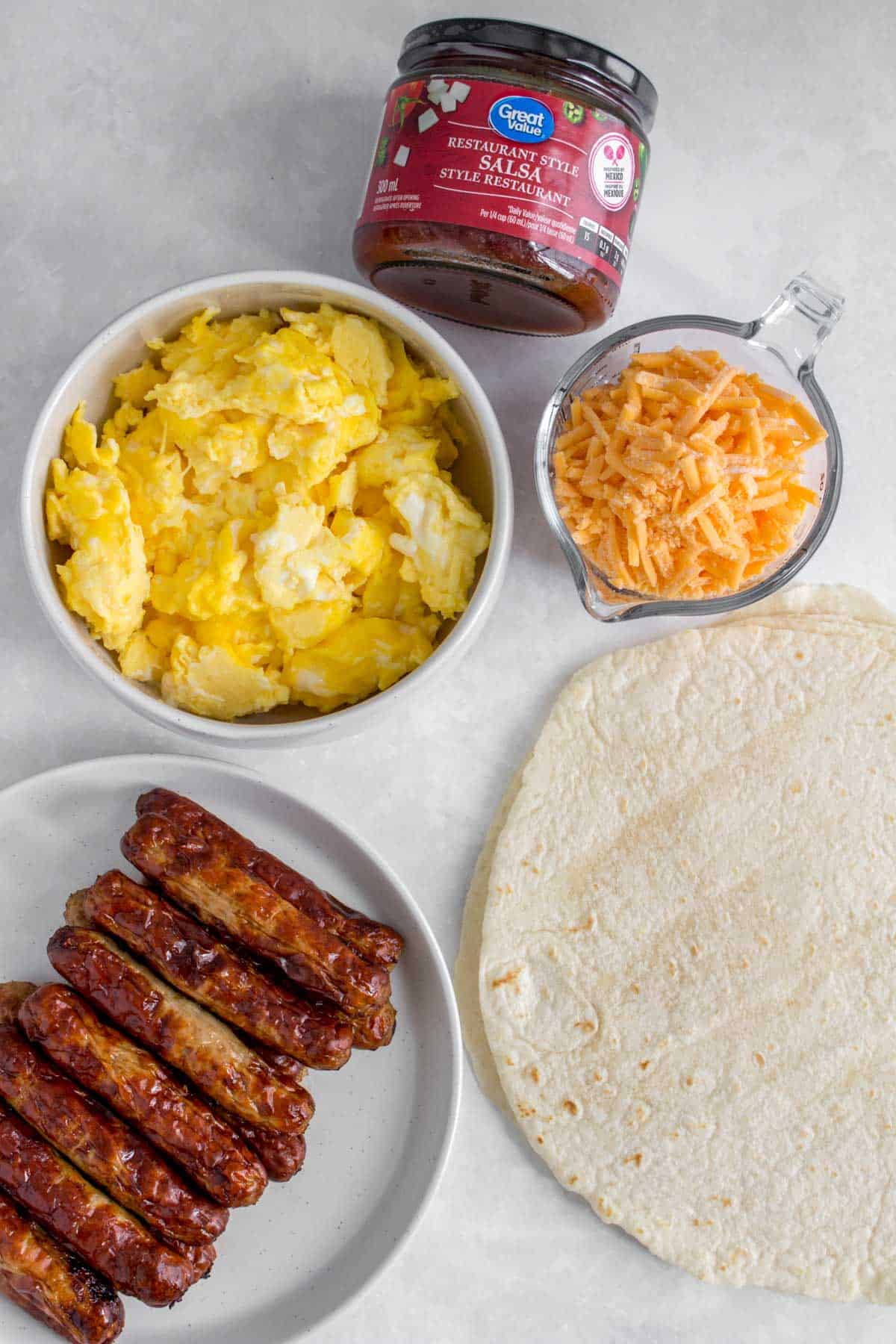 Ingredients needed for a sausage and egg breakfast wrap.