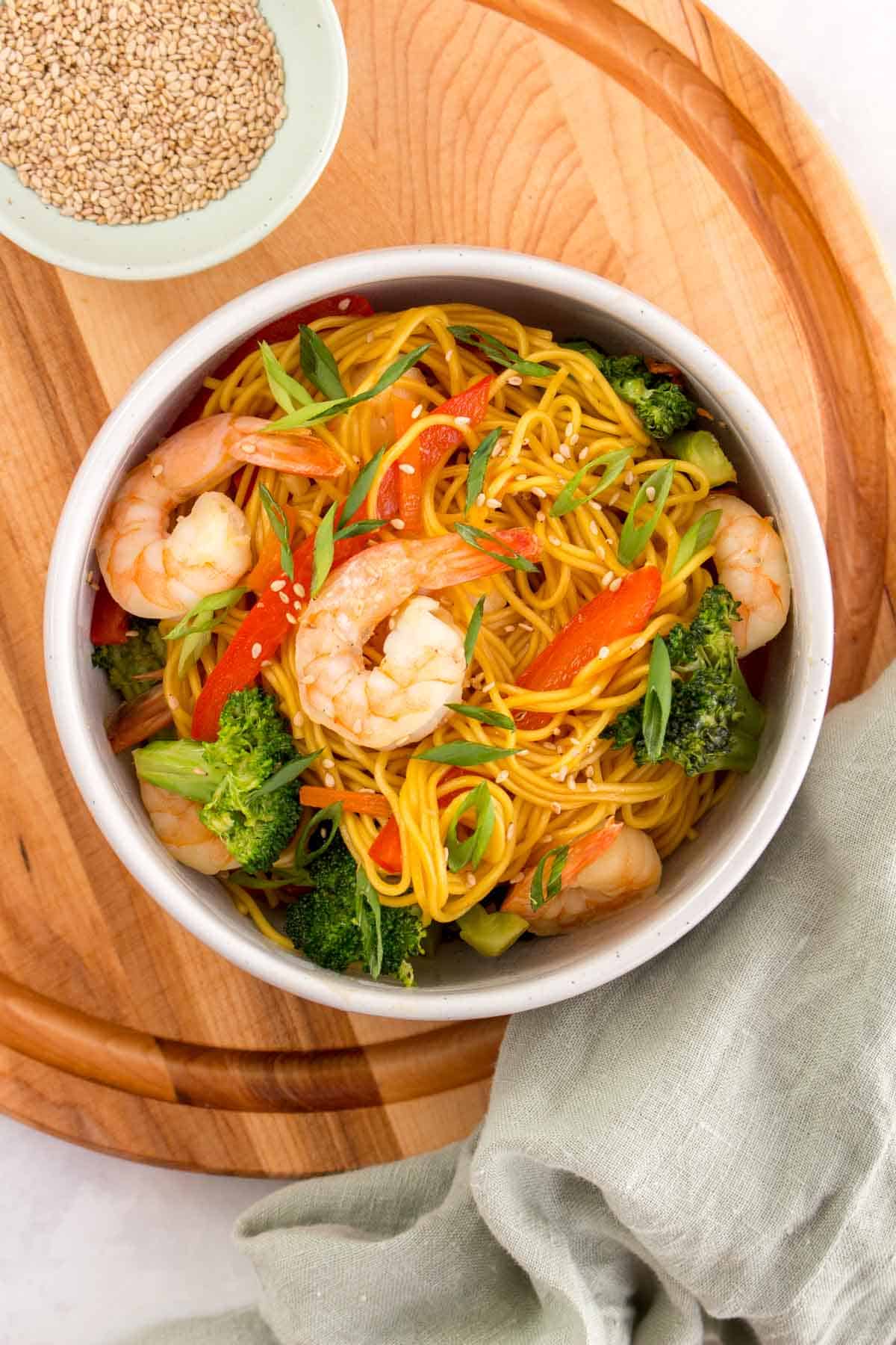 Overhead view of a bowl of shrimp stir fry noodles.