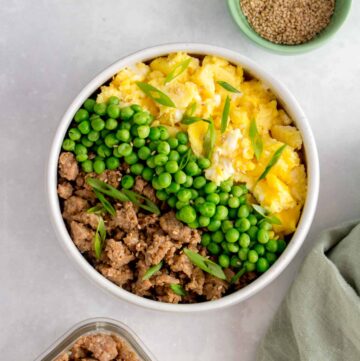 A ground chicken bowl with peas and scrambled eggs.