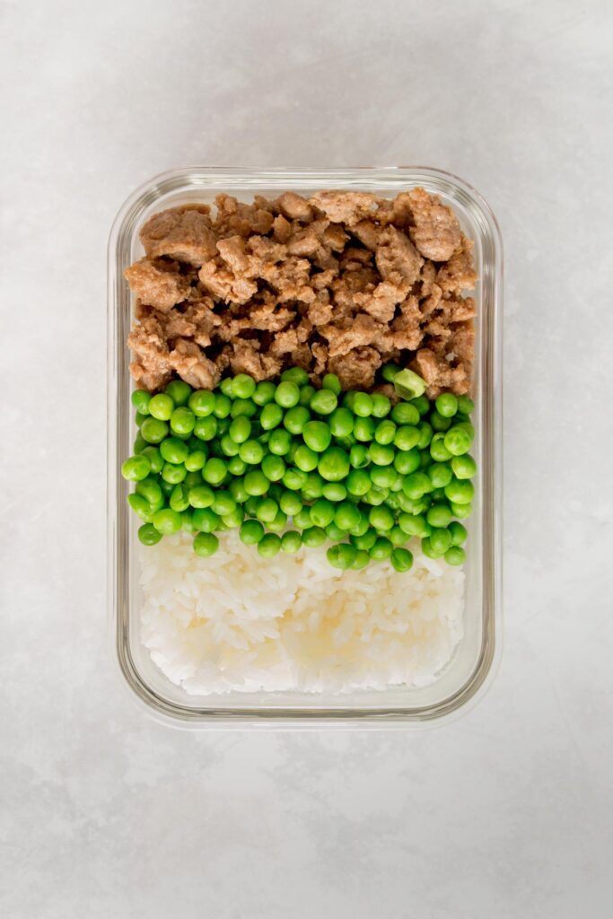 Peas added beside the ground chicken over rice.