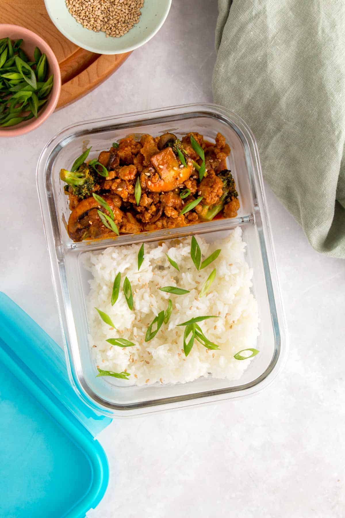 Meal prep container with rice and A plate of rice with spicy ground pork stir fry.
