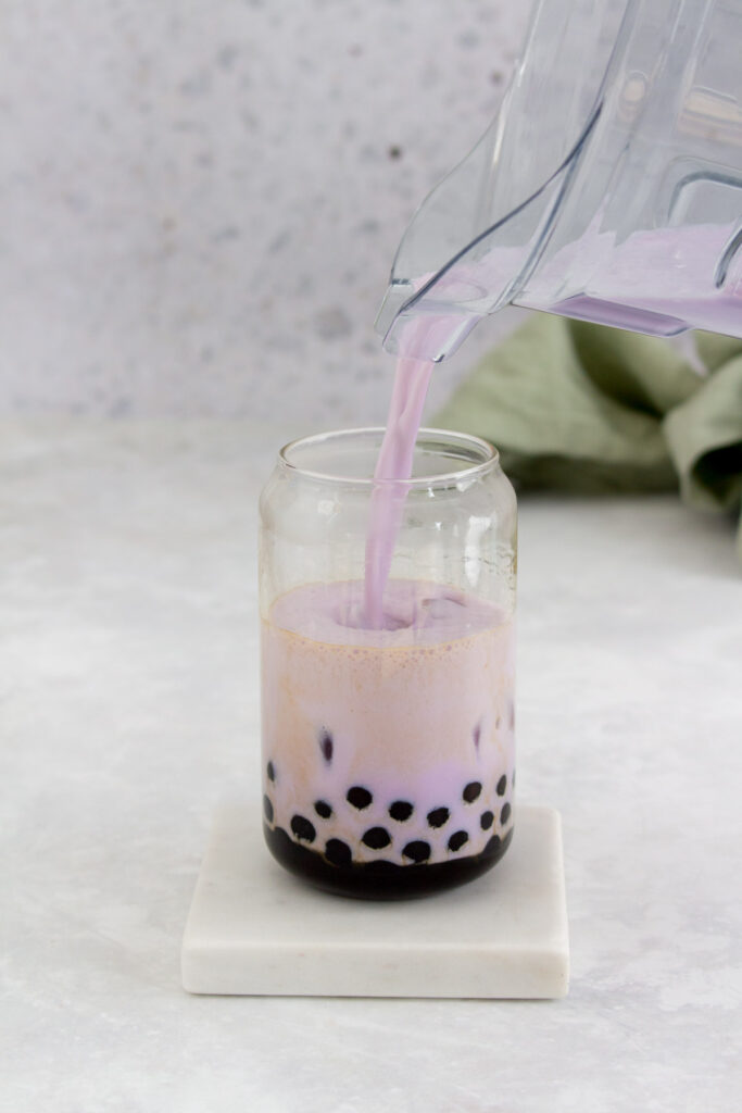 Taro milk added to the glass of tapioca.