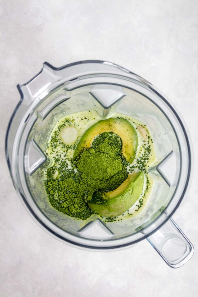ingredients for matcha avocado smoothie in a blender.
