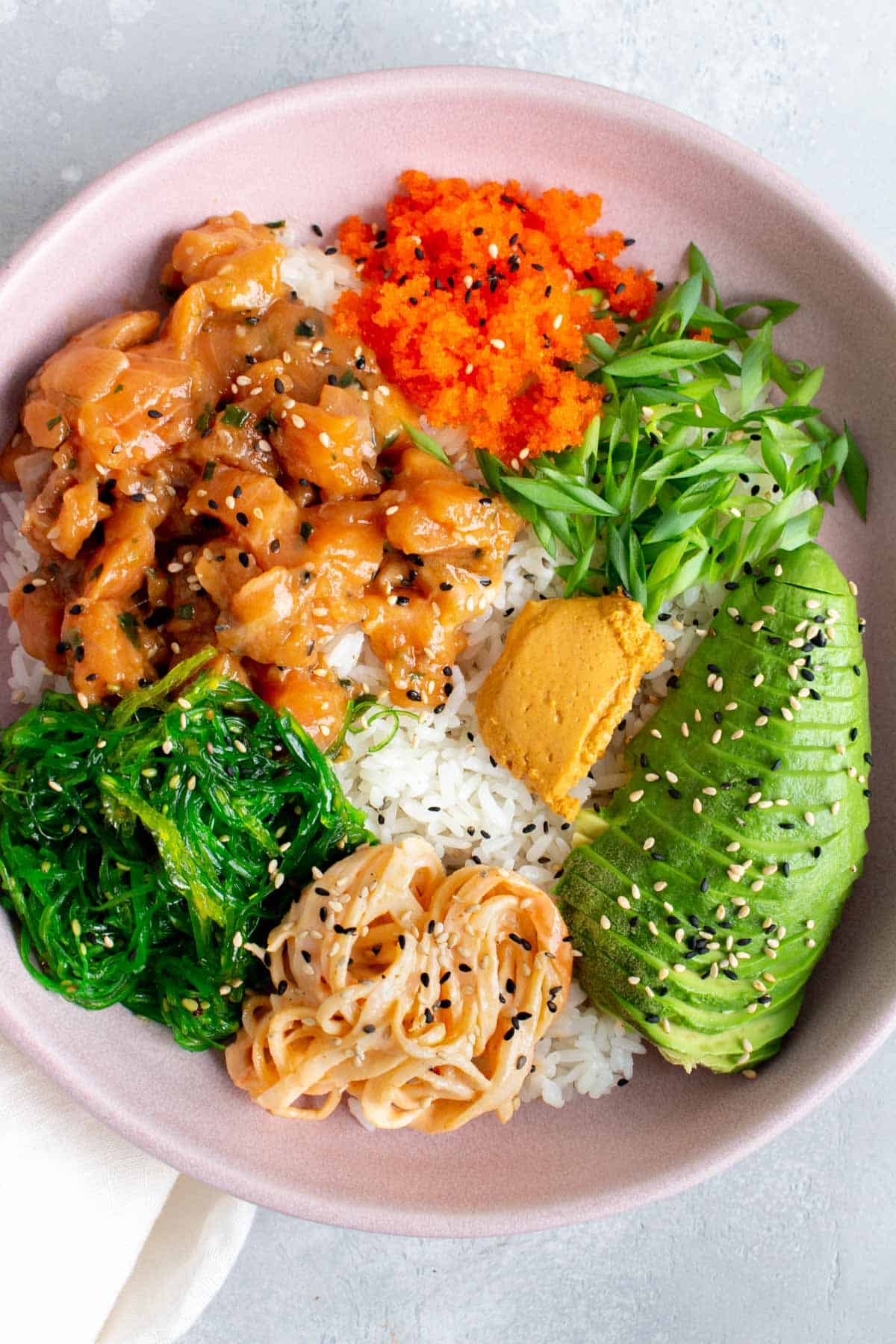 Close up of a poke bowl with various toppings.