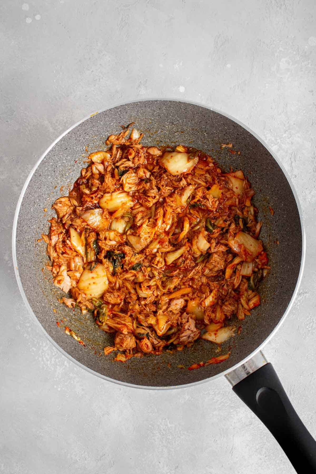 Kimchi, tuna, and sauces combined in a skillet.
