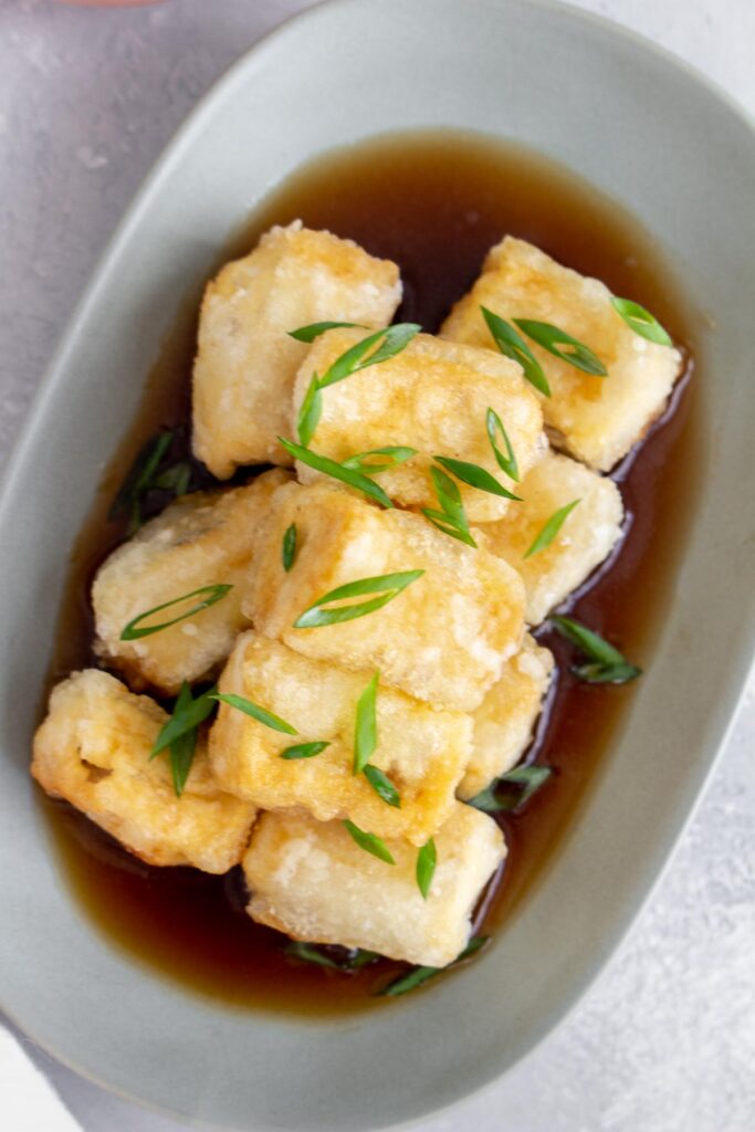 Overhead view of a plate of agedashi tofu.