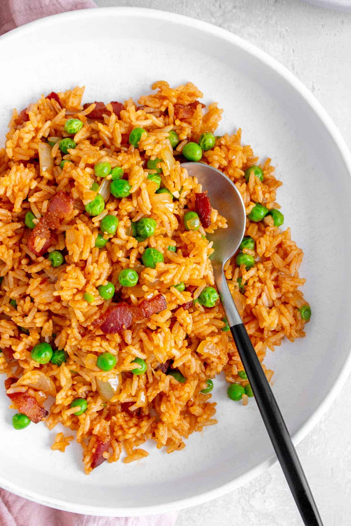 Close up of a plate of ketchup fried rice with a spoon.